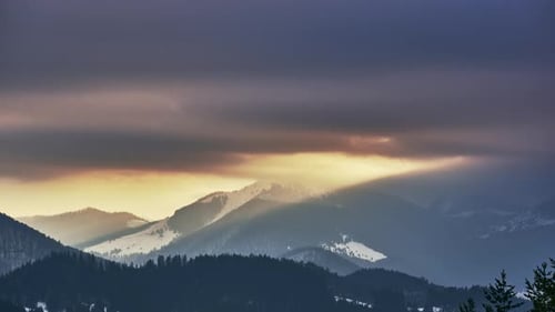 Sun Rays Over Winter Mountain Range at Sunset