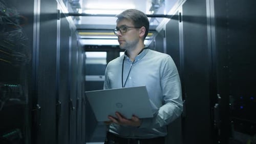 Walking Through Data Center IT Engineer Stops Before Working Server Rack to Do Routine Maintenance