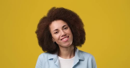 Smiling Attractive African American Woman Standing Over Orange Studio Background