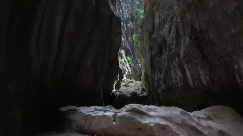 Drone is Flying in the Narrow Path with Massive Rocky Cliffs on Both Sides