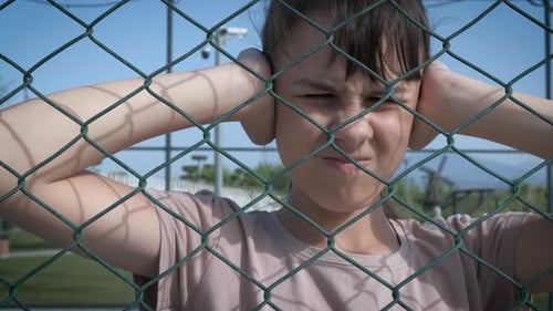 Teen Girl Covers Ears, Frustrated