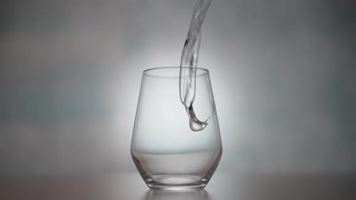 Clear Liquid Pouring Into An Empty Glass