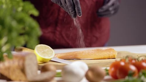 Seasoning Salmon Fillet on Cutting Board With Food