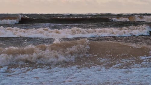 Sea storm with big waves at sunset. Strong waves on the sea coast. Selective focus