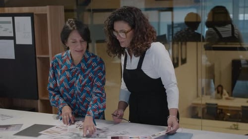 Ältere Kolleginnen diskutieren über ein Architekturprojekt