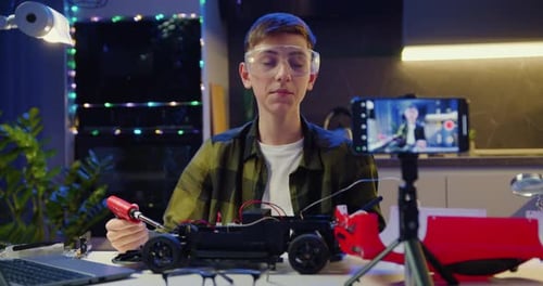 Teen Assembling a Toy Car for Online Video