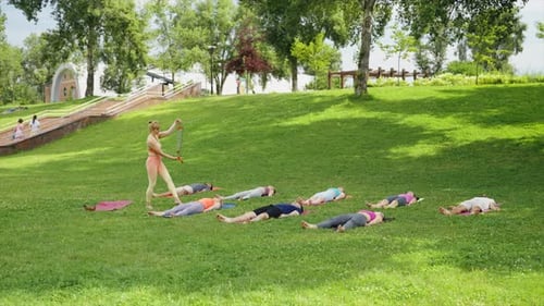 Yogi Woman Playing Swinging Chimes During Yoga Meditation in City Park
