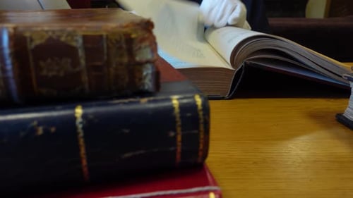 Man's hands leafing through an old book in the library