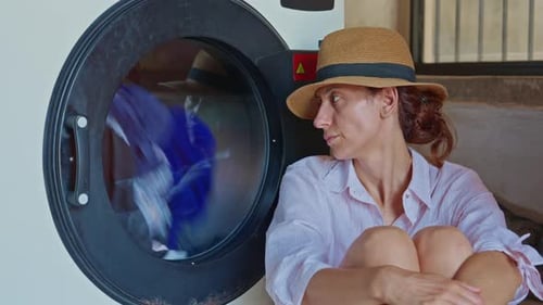 Woman Waits for Laundry in Washing Machine