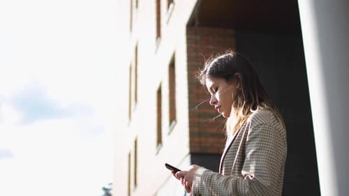 Young Woman Using Smartphone in Urban Setting