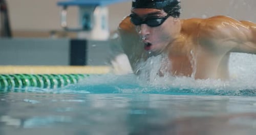 Professional swimmer with googles trains with effort and dedication to win the race by swimming in
