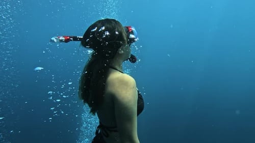 fille plongeuse libre montant au ralenti, plan moyen, plongée panoramique en apnée en Indonésie