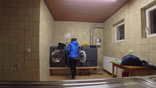 People Load Clothes into Washing Machine