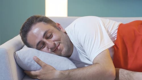 Homme souriant pendant son sommeil.