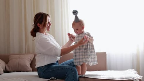 Junge lächelnde Mutter und kleines Mädchen genießen es, ihre Freizeit zusammen zu verbringen und zu Hause zusammen zu spielen. Tannen