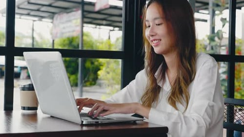 Asian Young Business Woman Lifestyle Using Laptop Computer at Cafe Coffee Shop