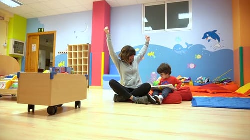 Woman Reading Book with Child in School Room