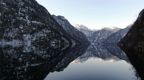 Aerial shot of the clear lake with reflections of the mountains in the water, 4k