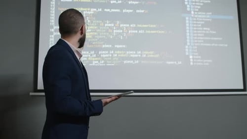 Männlicher Informatiklehrer erklärt die Codierungssequenz im Unterricht