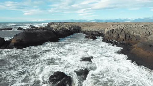 waves crashing black rocks in Iceland aerial footage