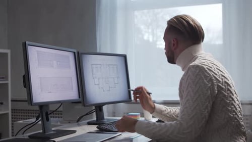 Architect Works in Loft Using Drawing Board Workplace of Young and Serious Engineer in Modern Office