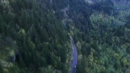 4K Aerial Top View of Curvy Road Through Autumn Forest in Mountains