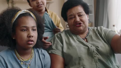Grandmother, Granddaughter, and Grandson Playing Video Games Together
