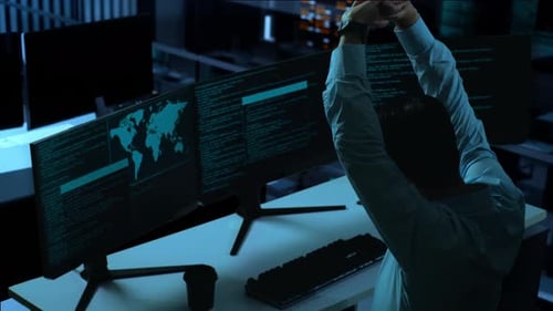 Side View Of Tired Asian Man Stretching While Write Code With Multiple Computer Screens In Office