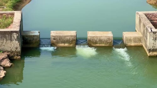 Concrete Check Dam with Flowing Water on Rural River