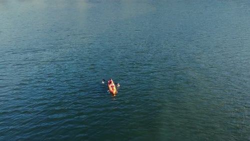 Aerial Fly Two People are Rowing a Boat Kayak on a Big Lake