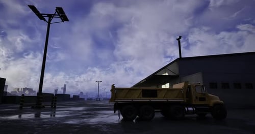 Yellow Truck Parked Under Cloudy Sky Near Industrial Building During Dusk