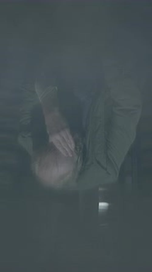 Distressed Individual Sitting on Stairs in Urban Night