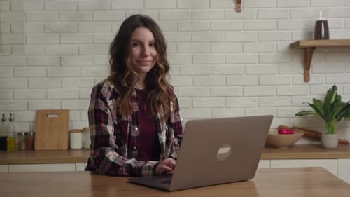 Woman Works on Laptop in Bright Kitchen