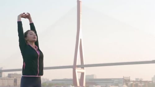Woman Stretching Arms Outdoors in Urban Environment