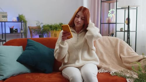 Woman Using Smartphone in Cozy Living Room