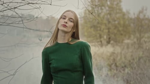 Model posing for photoshoot in nature wearing green dress