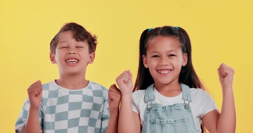 Niños, felices y celebrados en el fondo del estudio con aplausos por el éxito