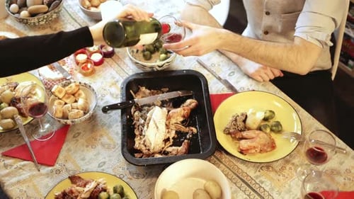 Overhead View of Friends Clinking Wine Glasses at Dinner