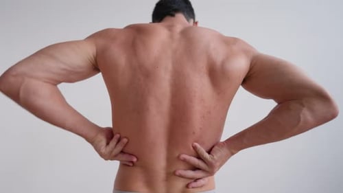Muscular Man Massaging Lower Back Muscles