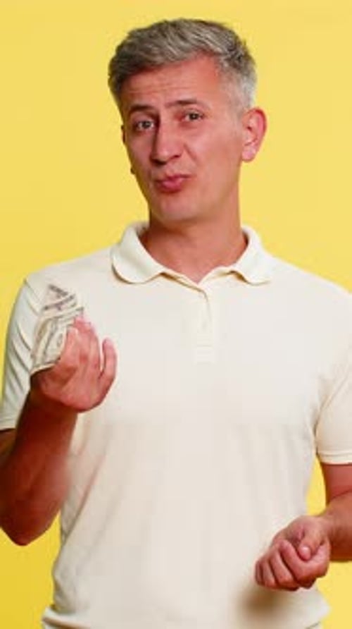Man Counts Money on Yellow Background