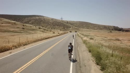 Course cycliste sur route ouverte entourée de montagnes et de ciel bleu 5 Active