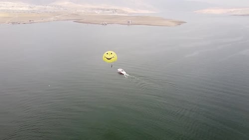 Aerial View of Parasailing Over Lake and Mountains