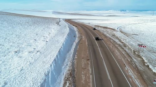 Aerial Shot of Cars Moving on an Intercity Road Among the Fields Covered with Snow Winter Landscape
