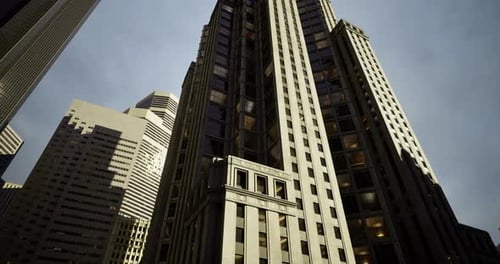 Los rascacielos se extienden hacia el cielo nublado en un entorno urbano con una luz Dramática