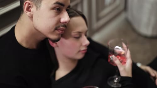 Romantic Couple Embracing, Holding Glasses of Red Drink