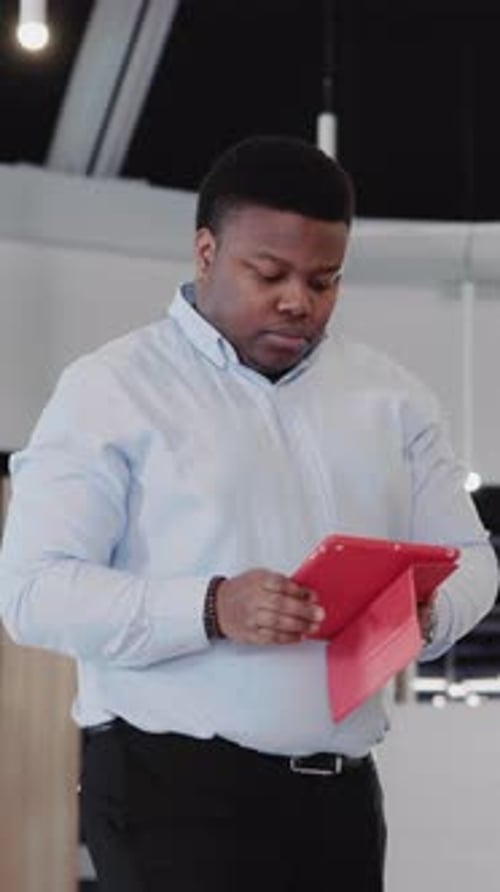 Black Young Office Manager Heading to Cabinet Using Tablet Application Computer Managing Business