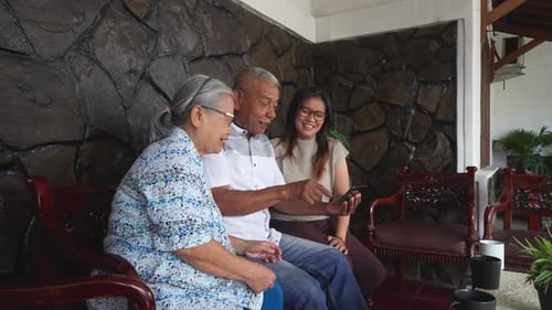 Family Sharing Mobile Phone Together and Laughing