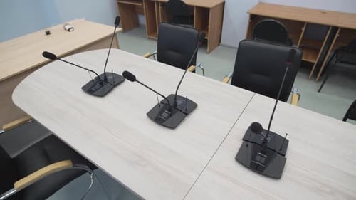 Conference Room with Microphones and Chairs in Modern Office