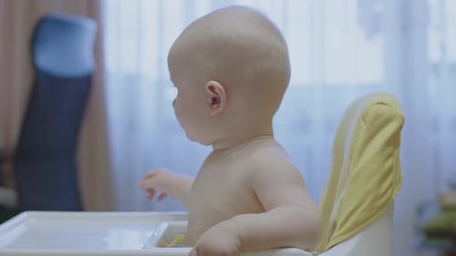 Infant Being Fed in a High Chair