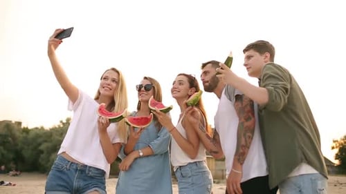 Friends Eating Watermelon Standing on Sandy Beach and Taking Selfies with Smartphone Camera Young